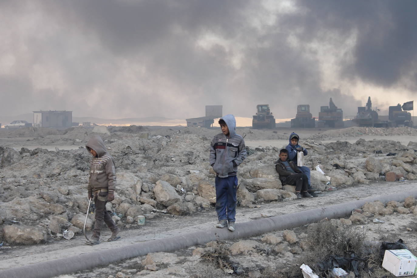 Niños iraquíes en Qayyarah contemplan la devastación causada por los incendios en los pozos petrolíferos. 