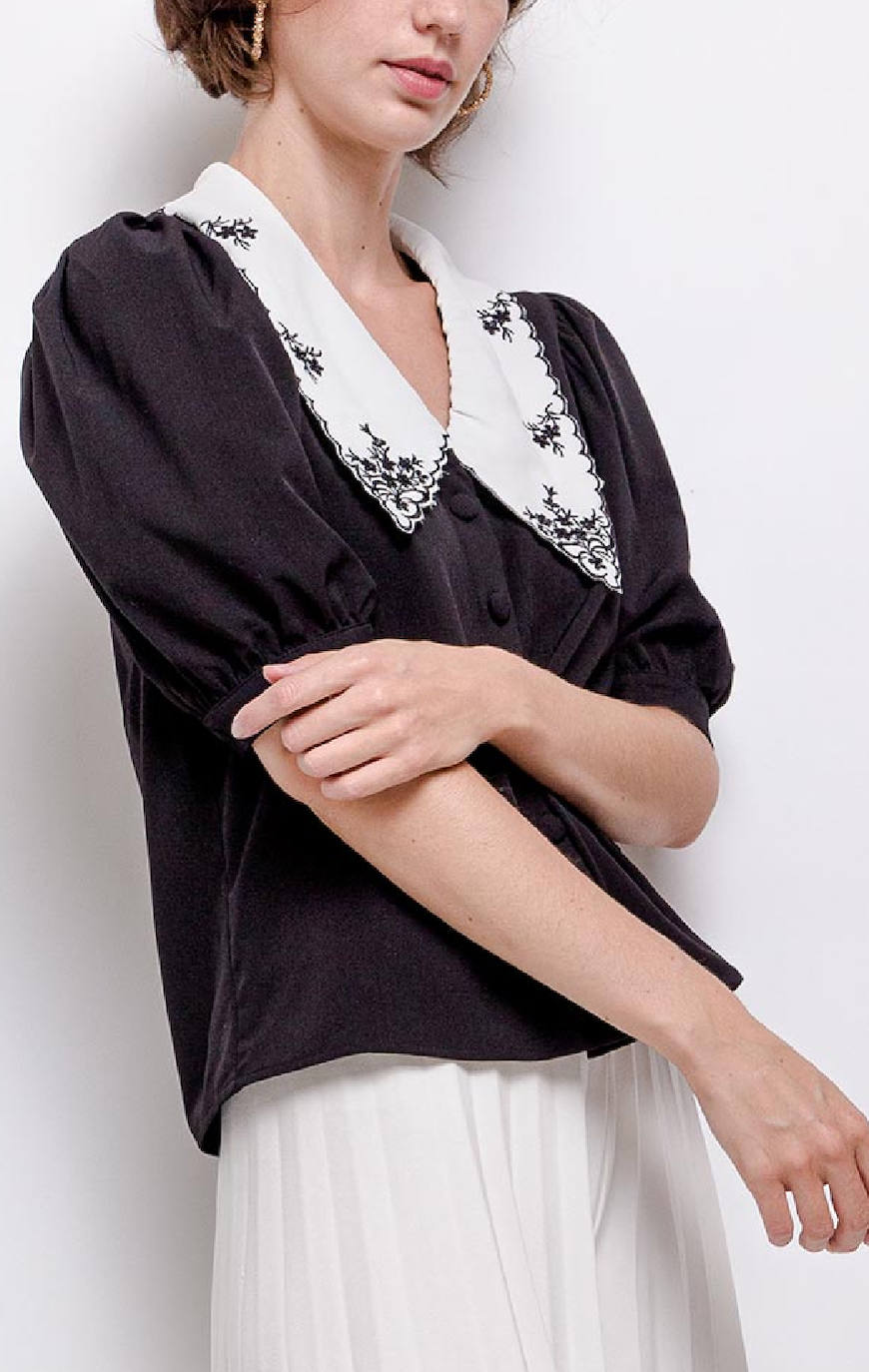 Camisa negra con cuello estilo babero blanco. Disponible en la tienda Uoma, situada en la calle bilbaína Rodríguez Arias. Cuesta 39,95 euros.