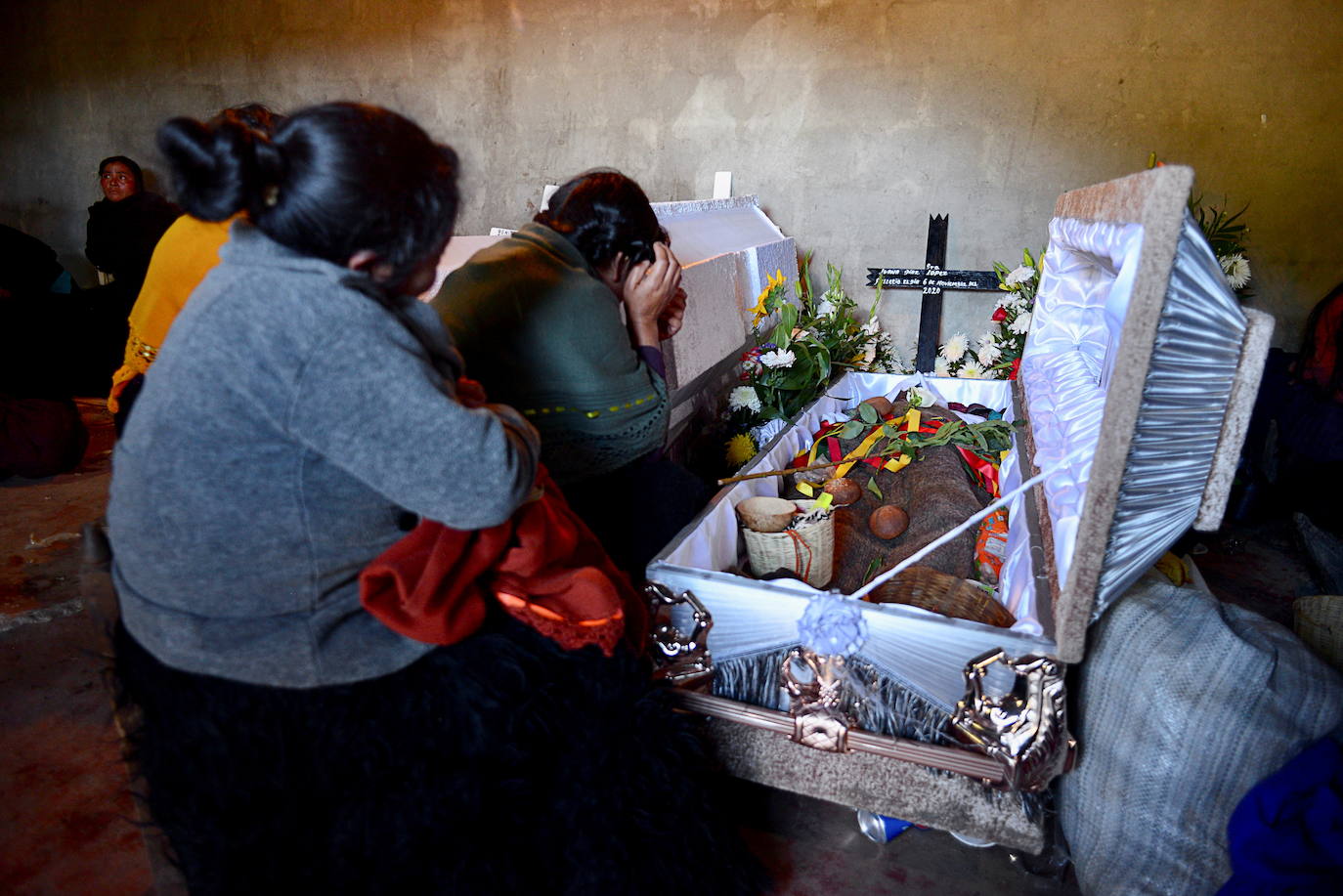 Las mujeres participan en un velorio por sus seres queridos, quienes murieron durante un deslizamiento de tierra provocado por las lluvias provocadas por la tormenta tropical Eta, en la aldea de Mukem, estado de Chiapas, México.