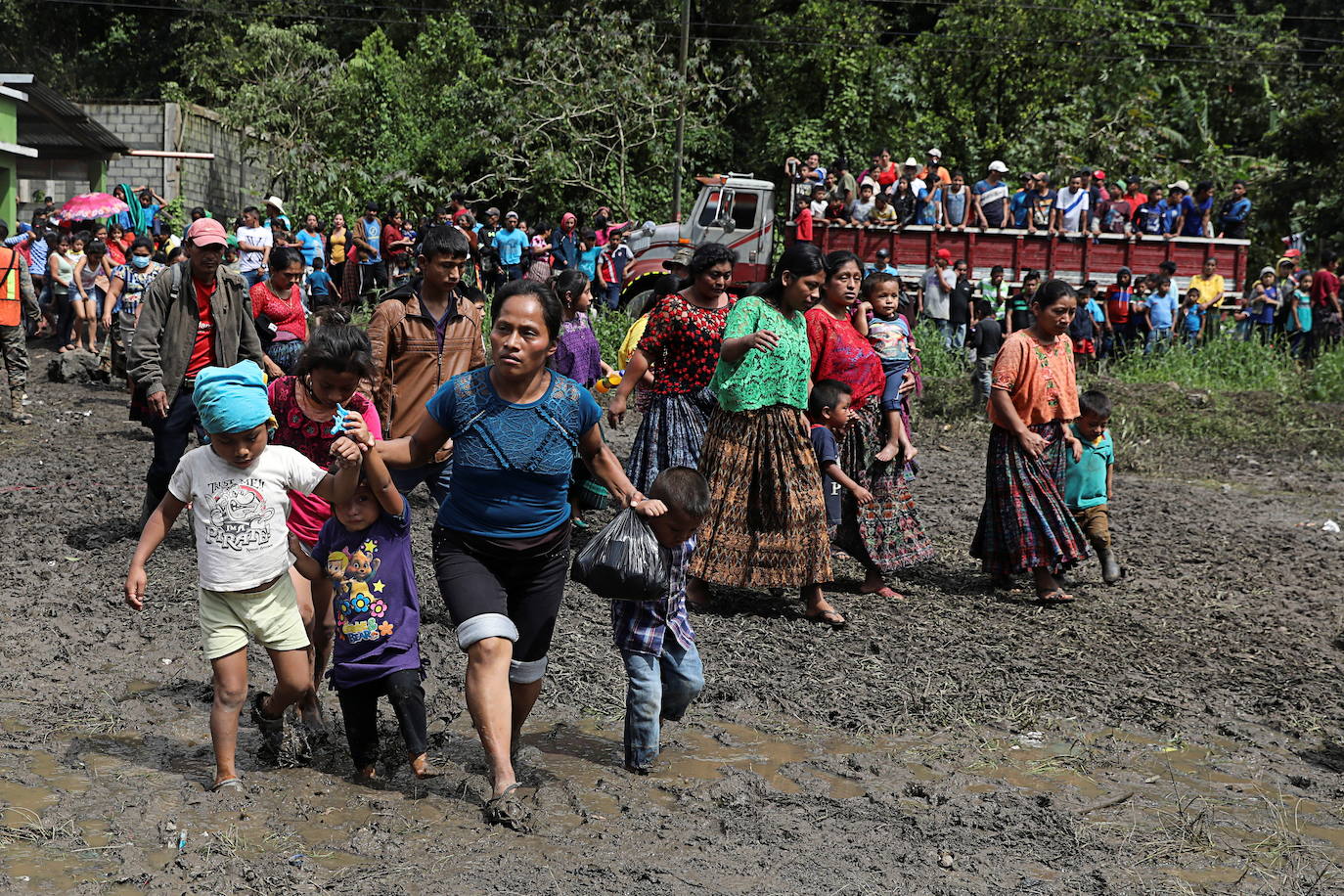 Personas caminan en un área escolar que está siendo utilizada como refugio temporal para residentes de pueblos vecinos afectados por los deslizamientos de tierra, debido a las fuertes lluvias traídas por la tormenta Eta, en el pueblo de Santa Elena, Alta Verapaz, Guatemala.