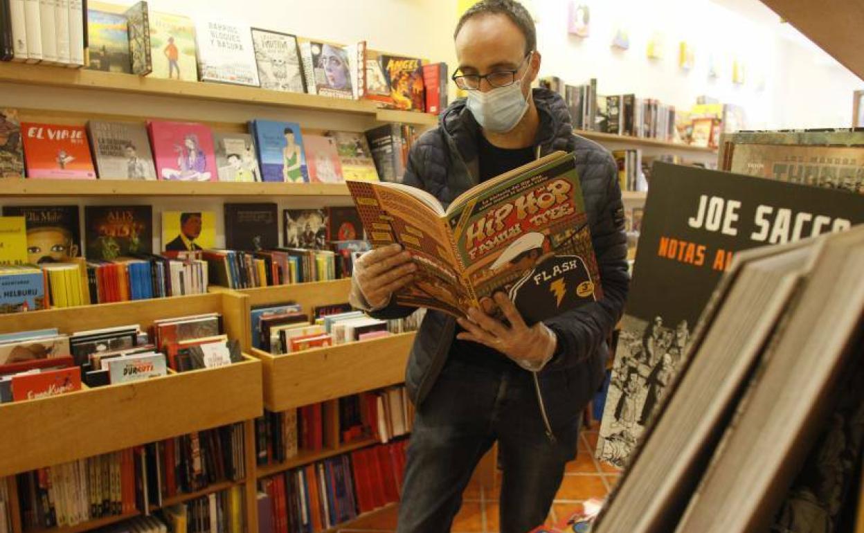 Un cliente en la librería Zuloa, con guantes y mascarillas. 