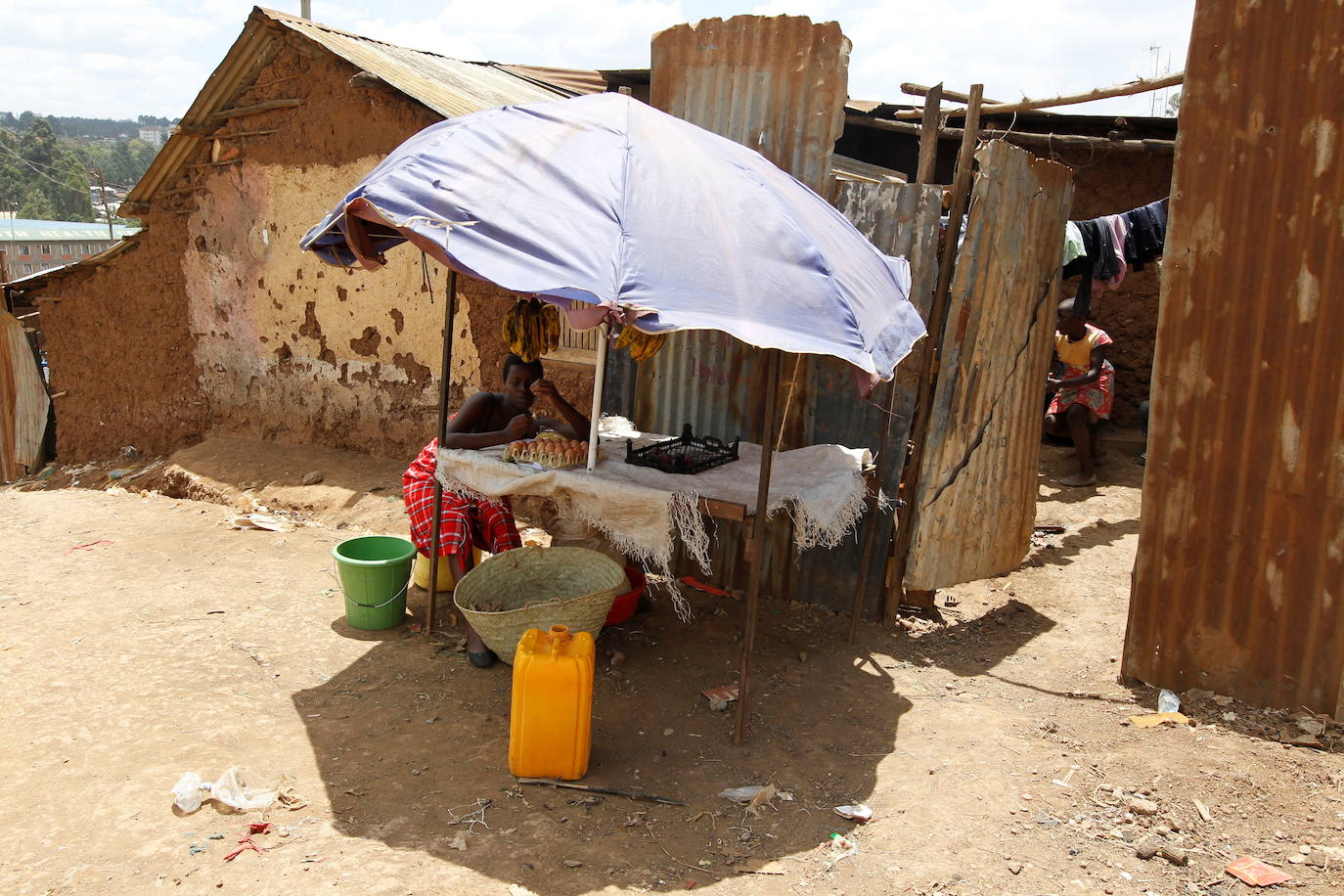 La estudiante de secundaria Jackline Bosibori, de 17 años, que está embarazada, espera a los clientes en una tienda improvisada fuera de su casa dentro de los barrios marginales de Kibera en Nairobi, Kenia.