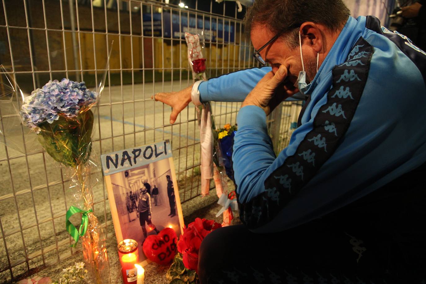 Un hombre llora frente a un santuario improvisado instalado en la entrada principal del estadio San Paolo en Nápoles.