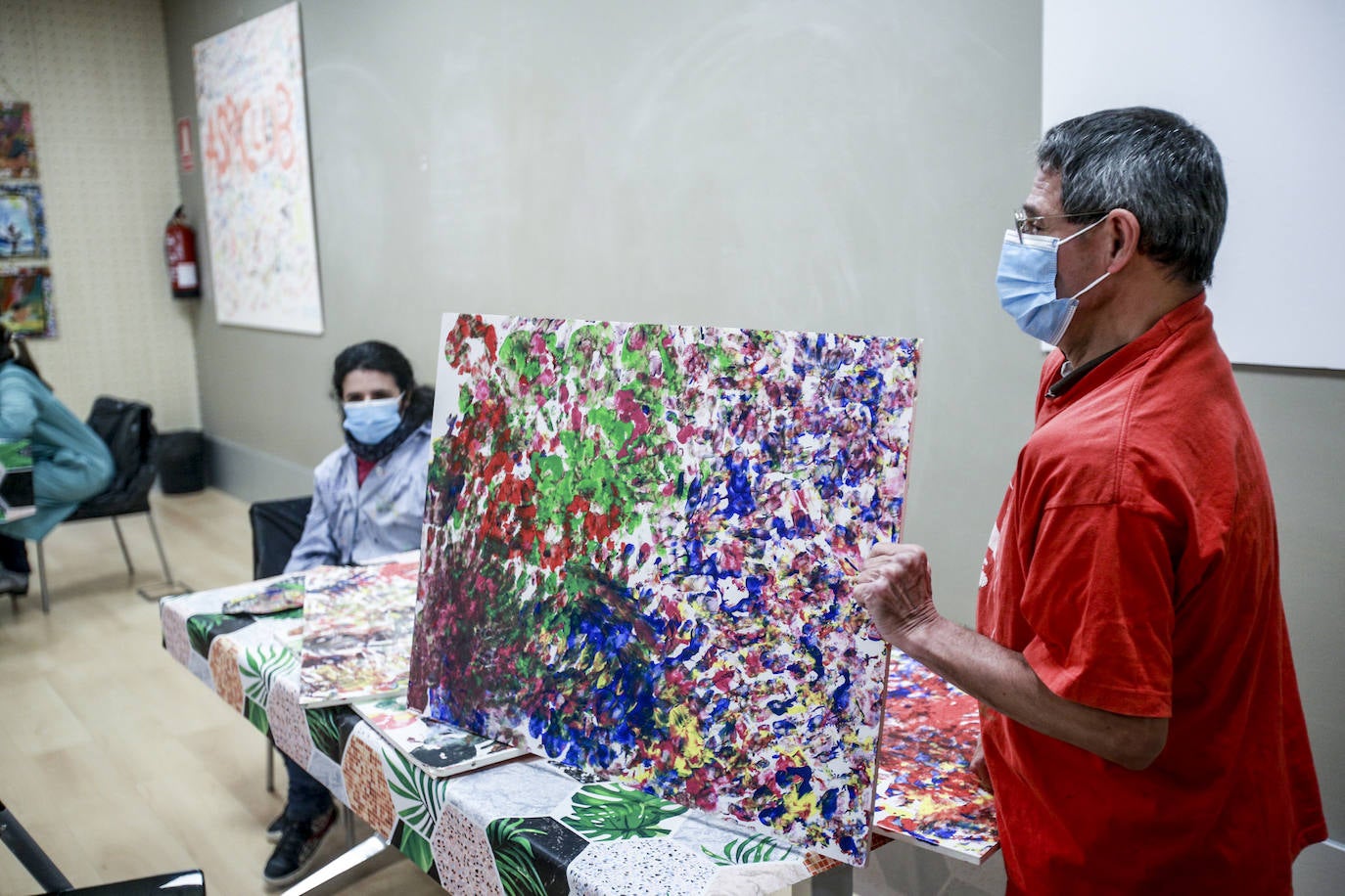 Usuarios y voluntarios participan en el taller de pintura de la asociación de parálisis cerebral Aspace, una de las numerosas actividades de las que disfrutan sus más de 130 miembros.