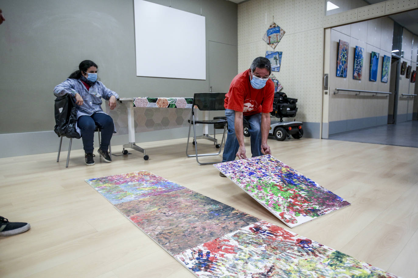 Usuarios y voluntarios participan en el taller de pintura de la asociación de parálisis cerebral Aspace, una de las numerosas actividades de las que disfrutan sus más de 130 miembros.