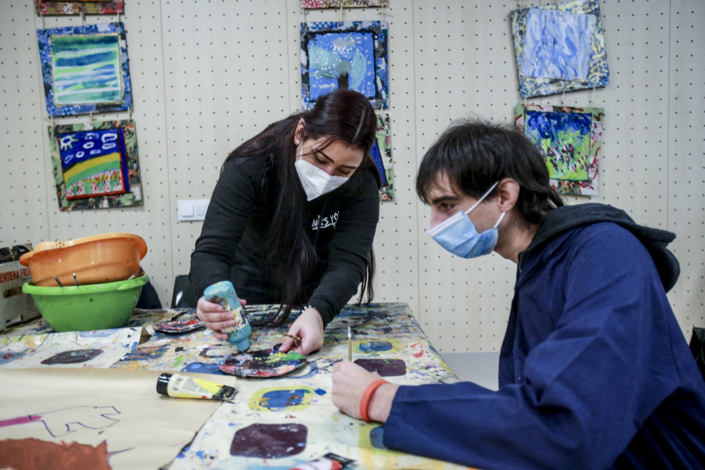 Usuarios y voluntarios participan en el taller de pintura de la asociación de parálisis cerebral Aspace, una de las numerosas actividades de las que disfrutan sus más de 130 miembros.