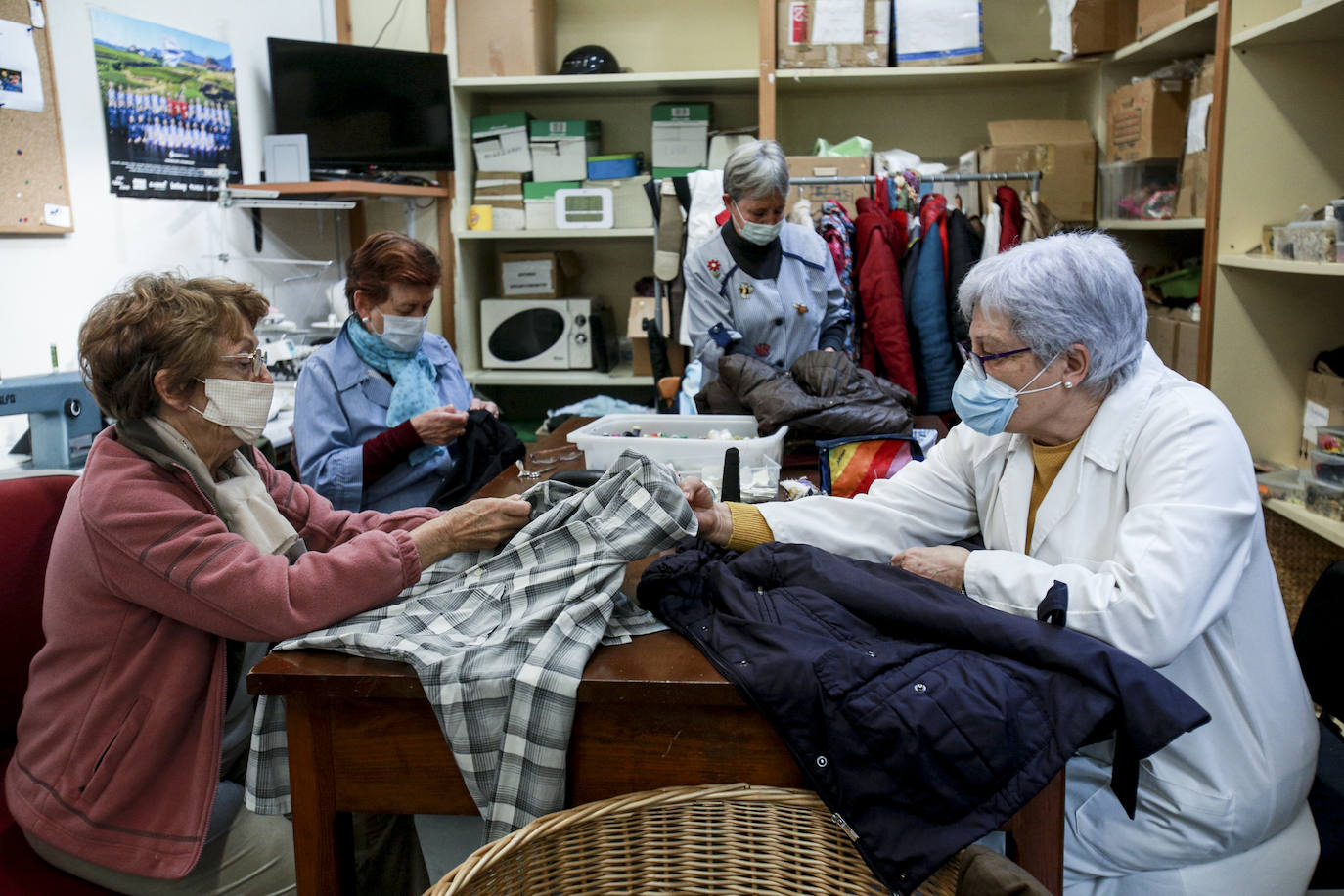 Voluntarias de Cáritas arreglan, lavan y preparan prendas recogidas en los contenedores que Koopera tiene repartidos por Vitoria para dejarlas listas para sus próximos dueños.