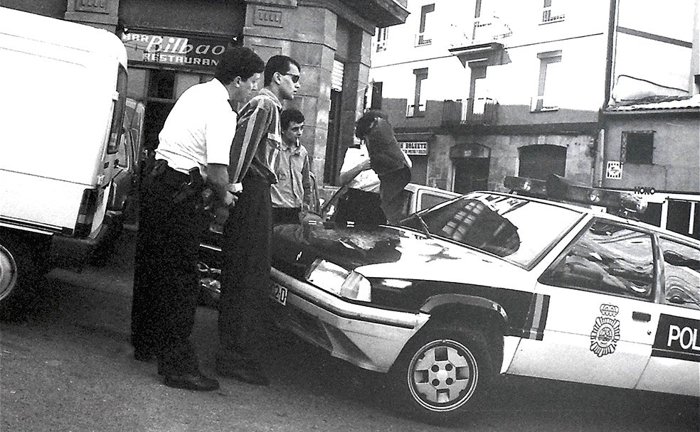Un miembro de las fuerzas de seguridad esposa a un detenido en Bilbao la Vieja.