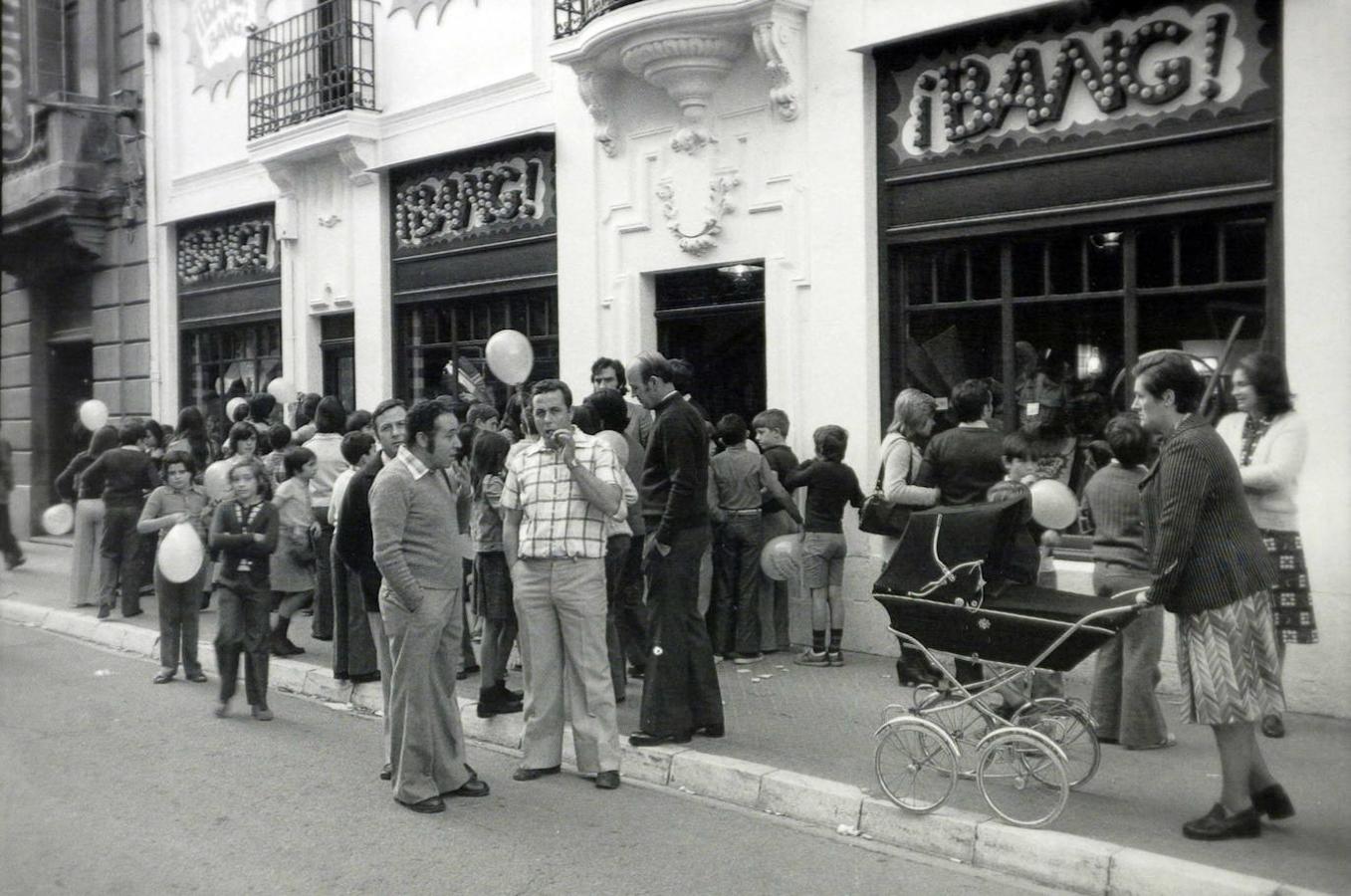 Cuatro rótulos en la fachada con la intimidante inscripción ¡Bang! daban la bienvenida a los curiosos que el 4 de octubre de 1975 se acercaron a la calle San Prudencio para asistir a la apertura de un nuevo comercio. «¡Bang! ¡Bang! trae a Vitoria el auténtico sabor de la moda deportiva», se anunciaba. Pantalones, jerséis, blusas, vaqueros, camisas, faldas, cazadoras, complementos... Unos cowboys a caballo y sobre una carreta del lejano Oeste entretuvieron al personal y repartieron regalos a la chavalería con un desfile a las puertas de la tienda. Con el tiempo cerró y el local lo ocupó Disco Ritmo, hasta que se asentó el establecimiento de Domingo Lafuente, viajero y joyero artesanal. El edificio sigue conservando su artístico frontal. Justo al mes de abrir ¡Bang! ¡Bang!, en la misma calle lo hizo la cadena de grandes almacenes Woolworth. Desembarcó antes que Galerías Preciados en una Vitoria que disfrutaba del progreso y el consumo. El comercio local se sintió intimidado por un competidor desconocido, pero celebró también la ocasión que se le brindaba para especializarse y mimar al cliente. Woolworth tiró los precios. Así, ofrecía dos slip de caballero por 99 pesetas, un panty ‘Deep’ de señora por 29 y un balón para el crío por 35 ptas.