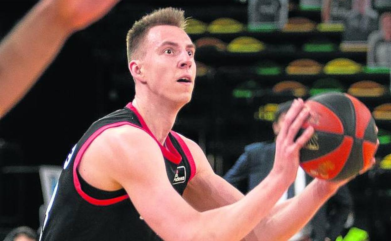 Los hombres de negro defienden su canasta durante una jugada. 