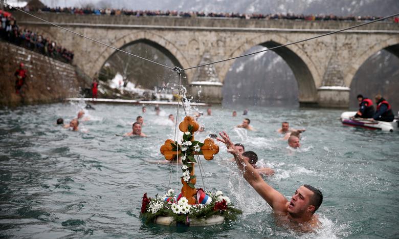 Bosnia y Herzegovina. Hombres nadan para recuperar una cruz del agua durante las celebraciones del Día de la Epifanía en Visegrad, Bosnia y Herzegovina.