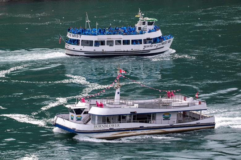 Canadá. El barco turístico estadounidense Maid Of The Mist, limitado al 50% de ocupación según las reglas del estado de Nueva York en medio de la propagación del coronavirus, pasa junto a un barco canadiense limitado según las reglas de Ontario a solo seis pasajeros, en Niagara Falls,