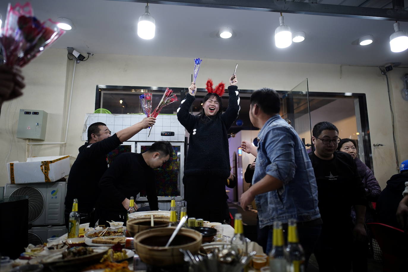 Jóvenes celebran un cumpleaños en un restaurante de la calle por la noche.