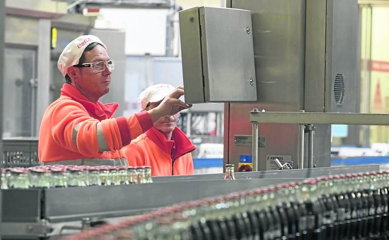 Dos operarios trabajan en la planta de Coca Cola de Galdakao. 