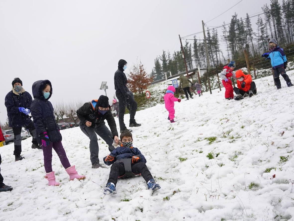 Niños y mayores juegan con la nieve en el puerto de Trabakua y en las cercanías del Oiz