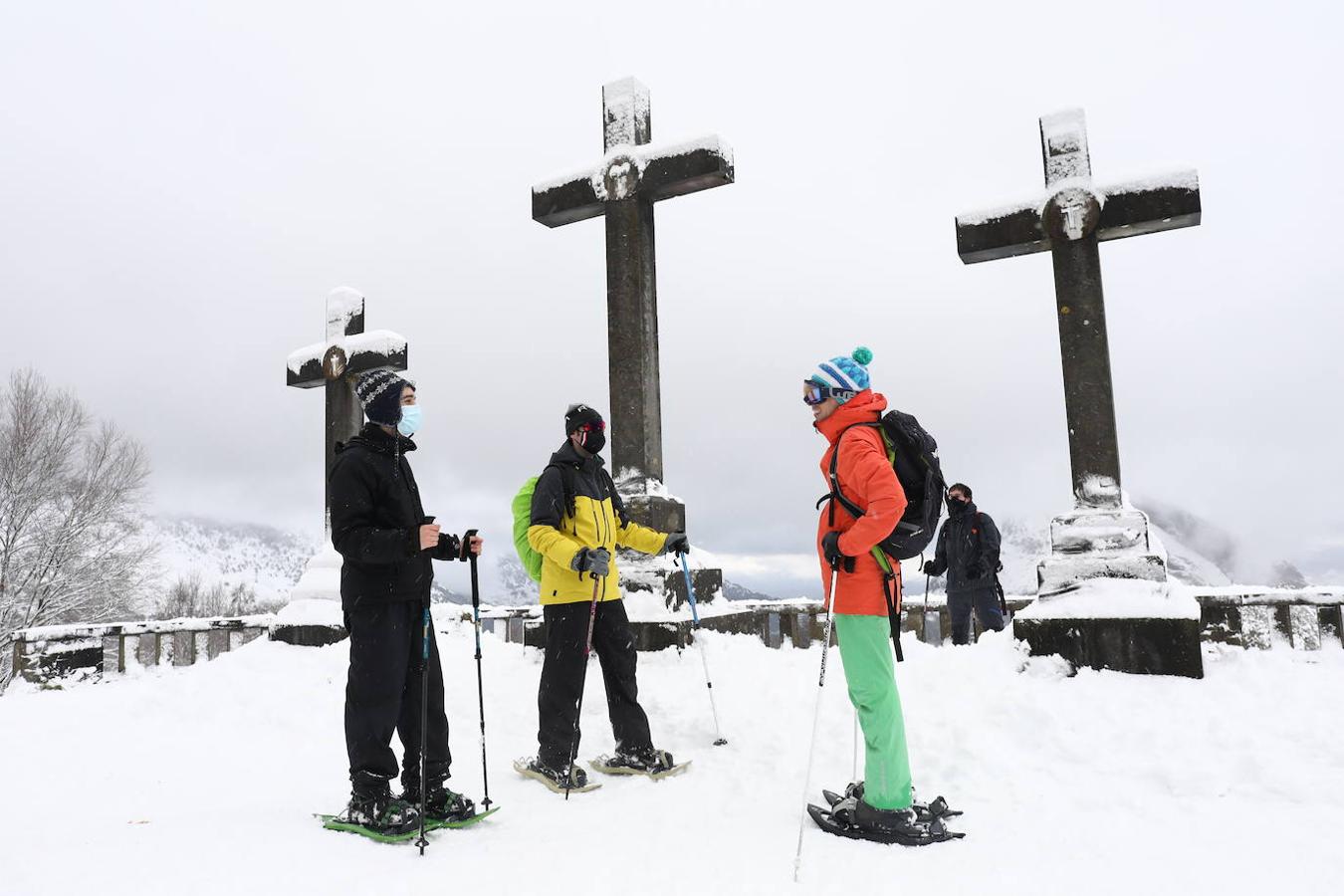 Tres jóvenes con raquetas de nieve conversan en Urkiola