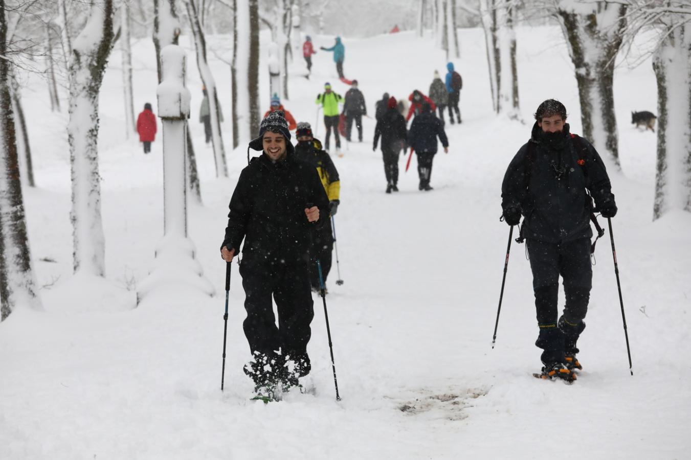 Dos jóvenes con raquetas de nieve.