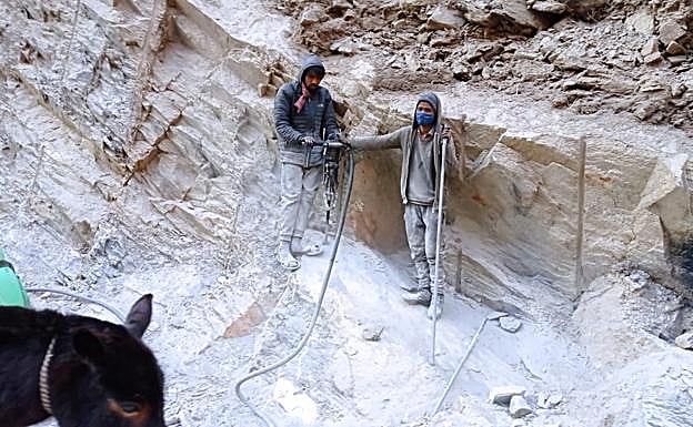 Trabajadores que perforan la tierra para colocar dinamita.