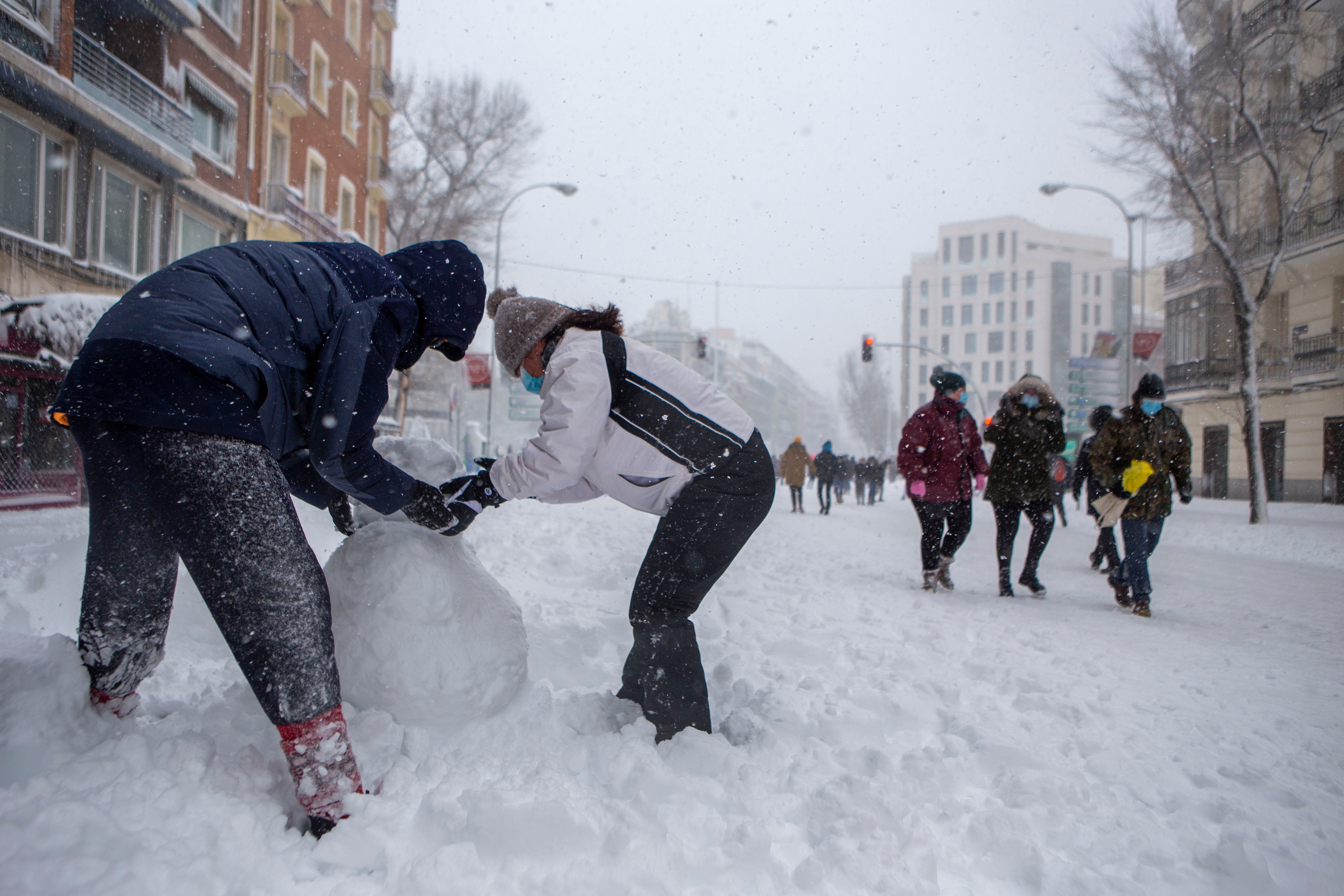 Dos personas hacen un muñeco de nieve en pleno centro de Madrid