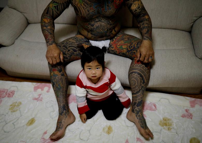 El trabajador tatuado del depósito de chatarra Hiroyuki Nemoto, de 48 años, posa para una foto con su hija Tsumugi de un año en su casa en Hitachinaka, prefectura de Ibaraki, Japón.