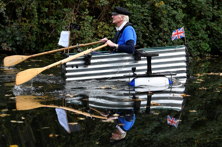 El veterano militar de 80 años Michael Stanley, conocido como Major Mick, rema su bote casero llamado "Tintanic" a lo largo de un canal como parte de su desafío de recaudación de fondos para recaudar fondos para St Wilfrid's Hospice, en Chichester, Gran Bretaña.