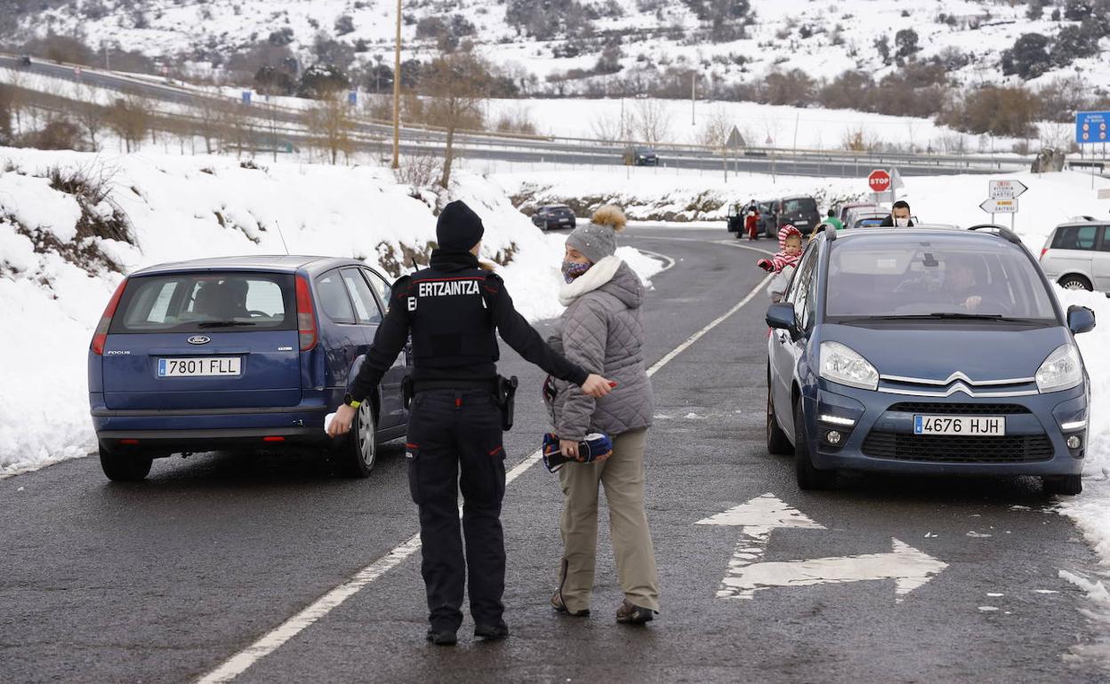 Una agente de la Ertzaintza conmina a una mujer a mover su vehículo en el camino a Letona. 