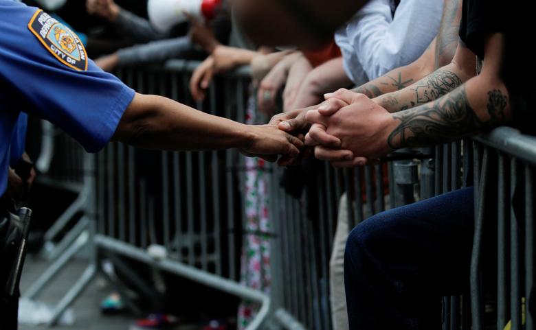 Un oficial de policía toca la mano de un manifestante.