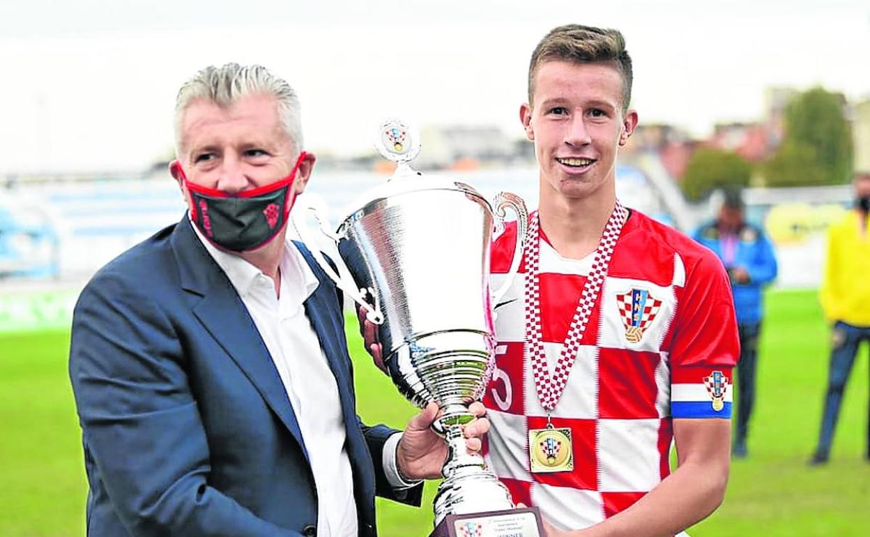 Zivkovic recibe un trofeo con la camiseta de Croacia. 