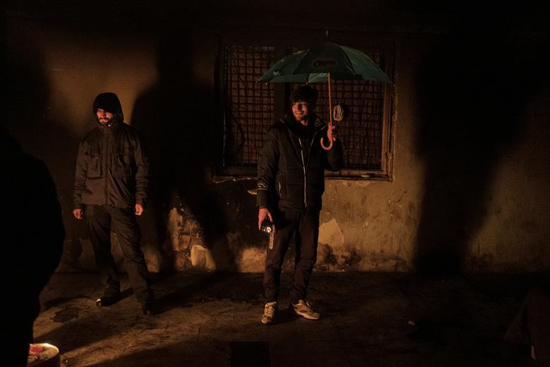 Los migrantes se calientan en una fábrica abandonada mientras cientos de ellos se refugian en edificios abandonados 