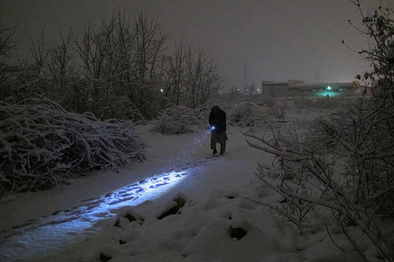 Un hombre camina fuera de la fábrica en busca de agua.