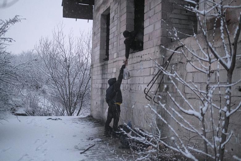Un hombre lleva suministros a una casa abandonada mientras cientos de ellos se refugian en la ciudad noroccidental de Bihac.