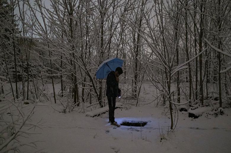 Un hombre sostiene una linterna mientras busca agua.