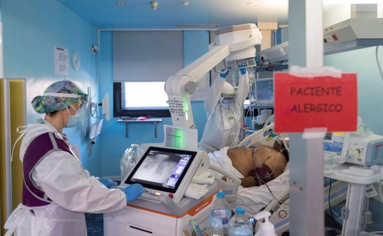 Una técnico de rayos hace una radiografía a un paciente de covid-19. 