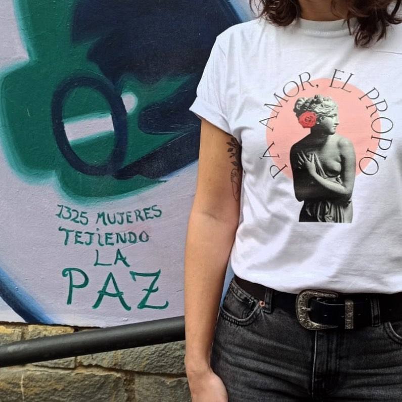 Camiseta de la firma vitoriana Akelarre con busto de mujer griega y la frase 'Pá amor, el propio'. Es de algodón 100% orgánico y tiene un precio de 26 euros.
