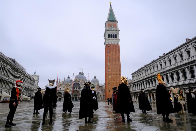 La gente usa máscaras y disfraces de carnaval en la Plaza de San Marcos para celebrar el carnaval anual de Venecia.