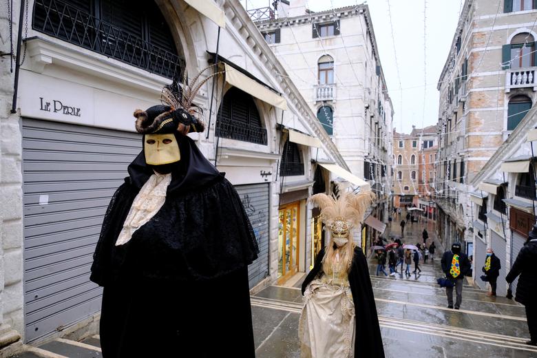 Los juerguistas usan máscaras y disfraces de carnaval para celebrar el carnaval anual de Venecia.