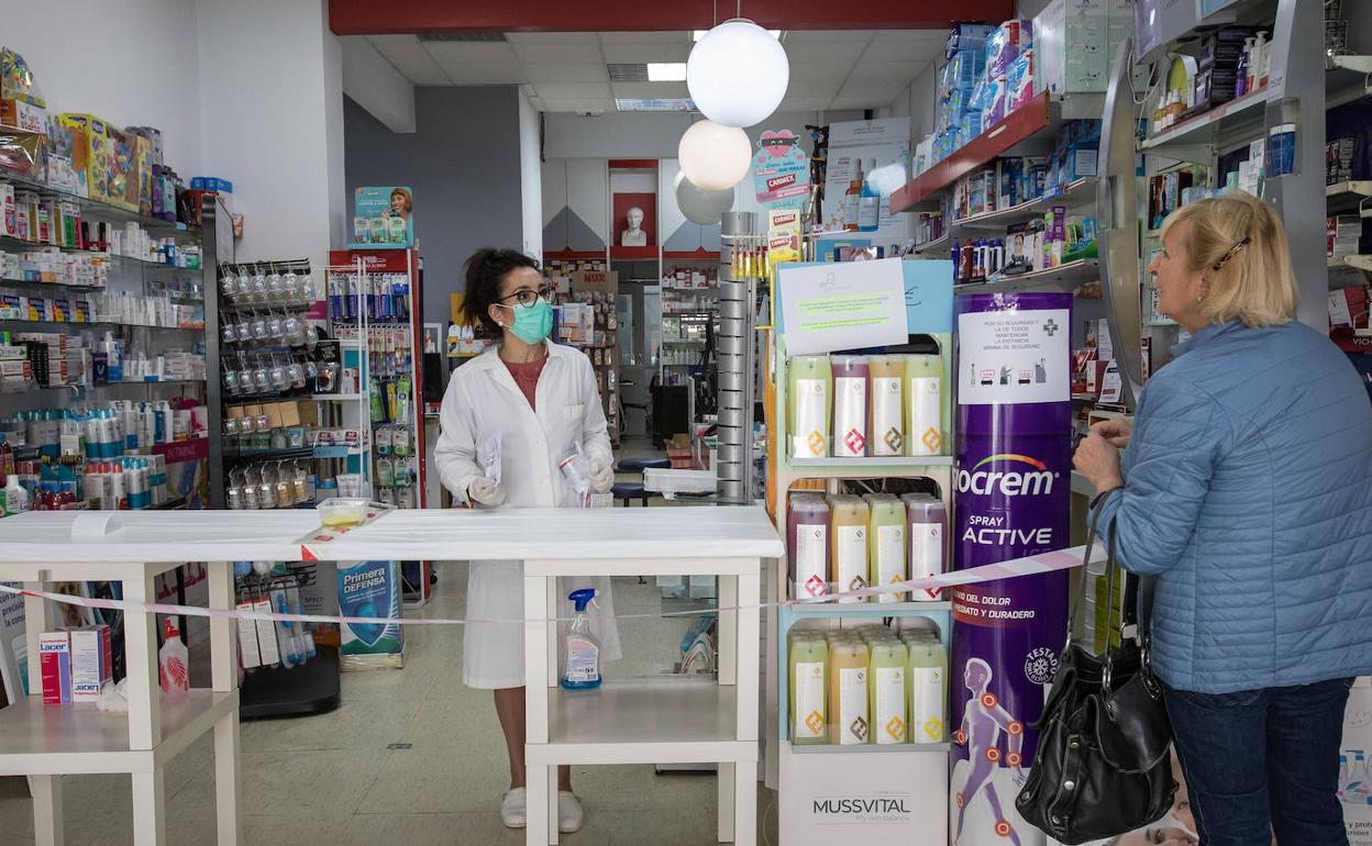 Una farmacéutica atiende a una clienta en Gernika. 