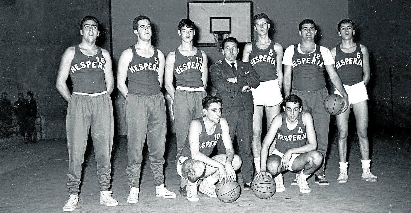 Cuando ya emitía inequívocas señales de deporte con porvenir y prestigio en Álava, a caballo entre los años 50 y 60, el baloncesto se puso a buscar y captar jóvenes que reunieran al menos dos cualidades. Que fueran altos, a poder ser de más de 1,90 metros, y apuntaran talento con el balón y en el tiro a canasta. La Federación Española promovió por entonces la práctica del minibasket como caladero, impulsó la llamada ‘Operación altura’ y creó un programa nacional con un club, el Hesperia, para agrupar a las promesas que fueran naciendo. Por descontado que Álava dispuso de su propio conjunto federativo, que venía a ser una selección de baloncestistas en edad juvenil mayoritariamente, procedentes del Vitoria, el equipo más representativo en aquel momento; y los colegiales San José, Marianistas y Corazonistas. El Hesperia vitoriano no tuvo larga vida, pero sí la suficiente como para integrar un elenco de buenos jugadores, algunos destacados en años posteriores, y hasta para ganar al Hesperia de Madrid, con lo más granado de la época, en un amistoso celebrado el 2 de marzo de 1963 en el Frontón Vitoriano. En la foto, que corresponde a un entrenamiento previo, posan de arriba a abajo y de izquierda a derecha, Lapeña, San Miguel, Perico Buesa, Javier Añúa (entrenador), Ibarrondo, Jesús Llano y Botaz; José Luis Ortiz de Pinedo y Echevarría.