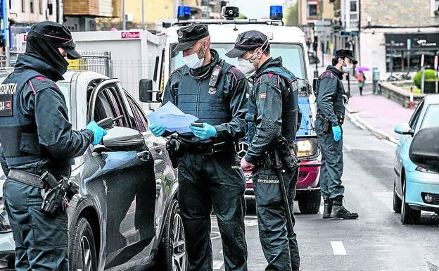 Agentes de la Ertzaintza revisan la documentación de un ciudadano durante el confinamiento.