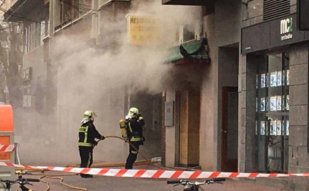 Los bomberos trabajan en el interior del local para conocer las causas de la explosión.