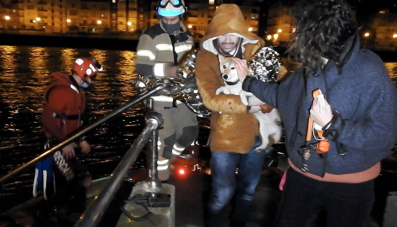 Momento en el que el perro y su dueño, empapados, son rescatados por la embarcación de la Cruz Roja.