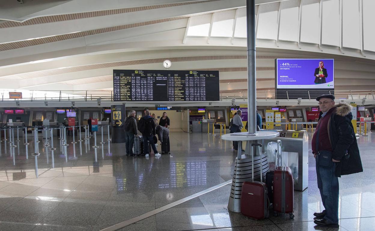 Un hombre espera en la terminal del aeropuerto.