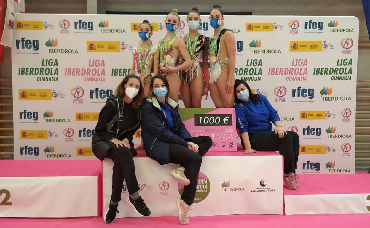 Iratxe Gárate, Izaro Martín, Salma Solaun y Saioa Agirre posando con las medallas y el cheque junto a sus entrenadoras. 