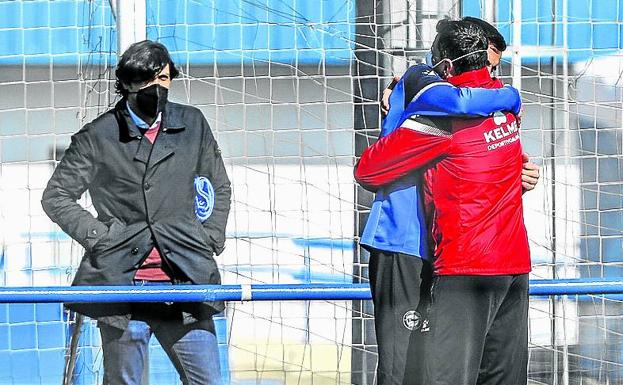 El abrazo de Joselu y un preparador, ante la mirada de Sergio Fernández. 