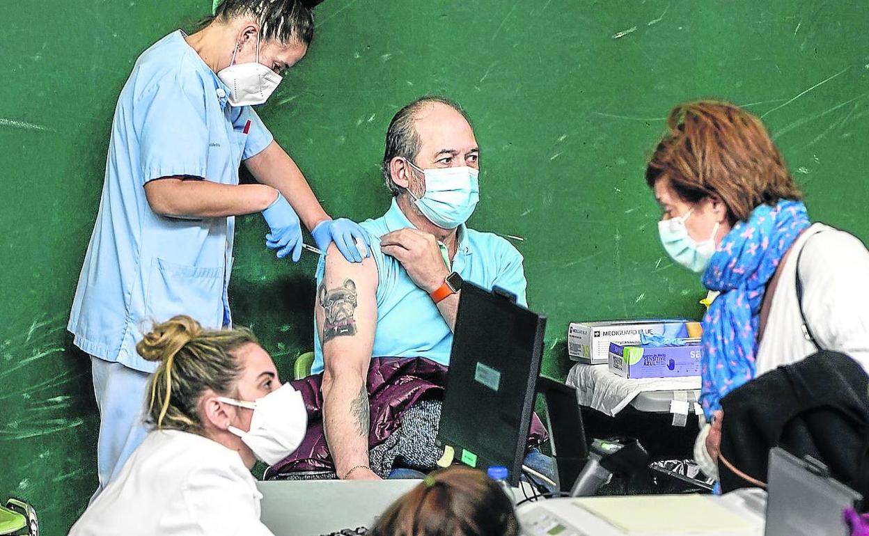 Un hombre recibe el pinchazo en uno de los seis puestos abiertos ayer del 'vacunódromo' de Lakua -hay capacidad para diez-.