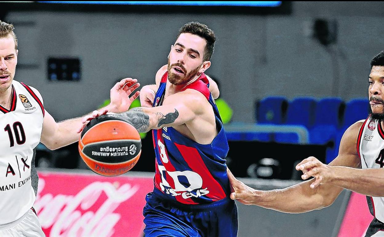 Luca Vildoza trata de superar a los estadounidenses Michael Roll y Kyle Hines, del Olimpia Milán, durante un partido reciente de EuroLiga. 