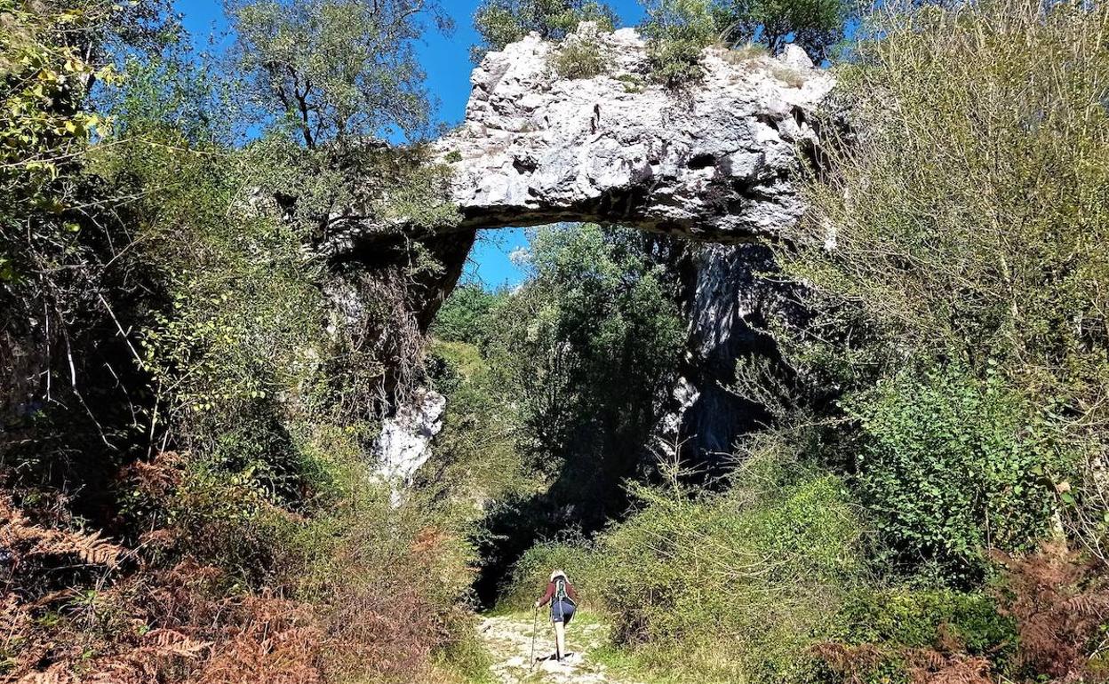 Una montañera se acerca al arco de Jentilzubi.