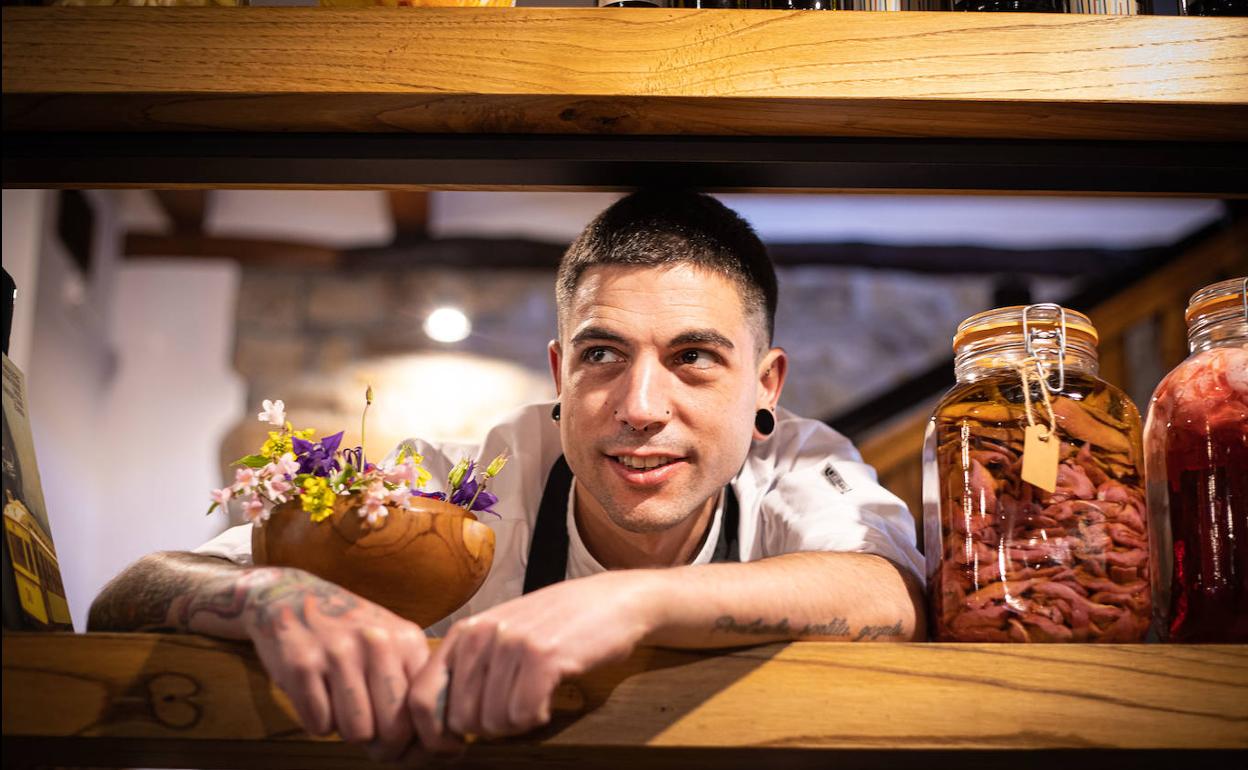 Julen Baz Múgica (Amorebieta, 33) posa en la estantería del Garena donde prepara infusiones de pétalos de rosas y encurtidos de pichón que usará en sus gildas. 