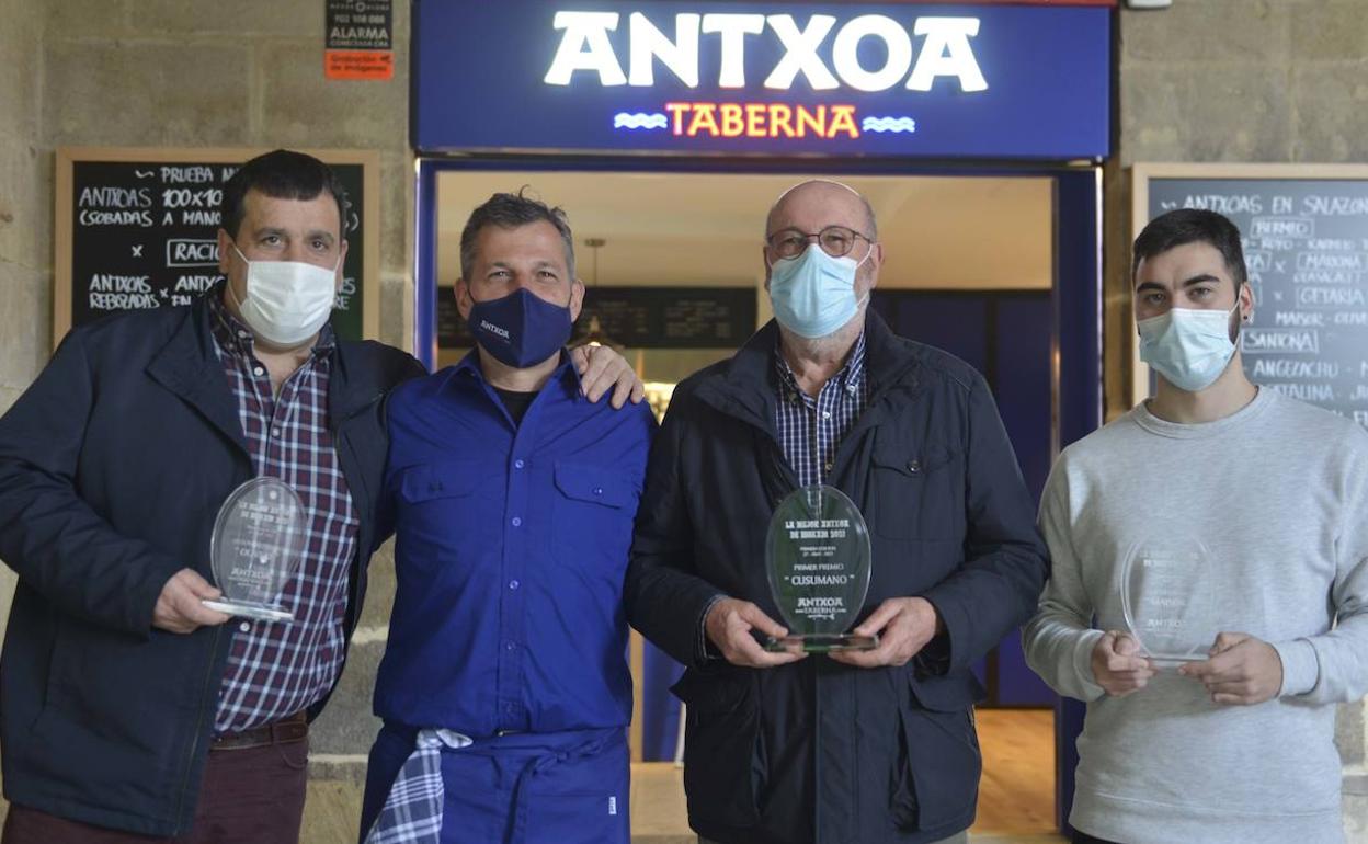 Los premiados y el propietario del bar Antxoa posan con los premios.