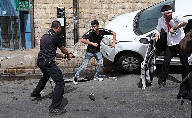 Imagen del policía israelí defendiendo a los ocupantes del coche. 